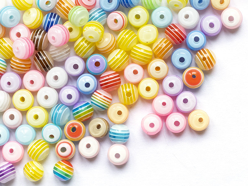 Achat 100 perles en plastique rondes 6 mm - rayures